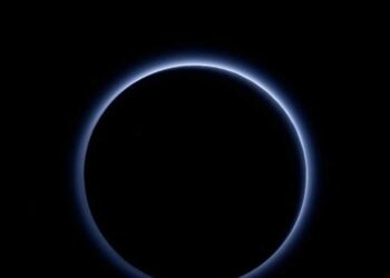 الفضاء الأسود يقطعه الغلاف الجوي الضعيف لبلوتو على شكل دائرة بظلال زرقاء