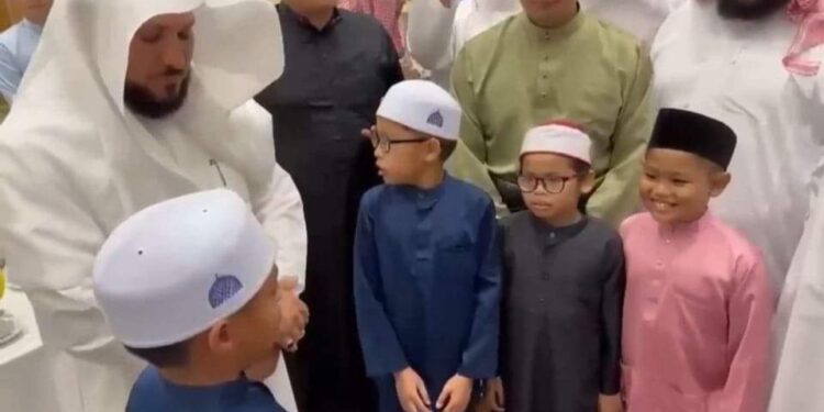 شاهد .. إمام الحرم المكي يقبل رأس طفل ماليزي يقلد صوته ويسأل الله له الصلاح وحفظ كتابه العزيزه